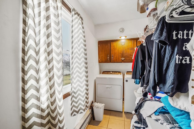 laundry room with cabinets, a baseboard radiator, washer and clothes dryer, and light tile patterned floors