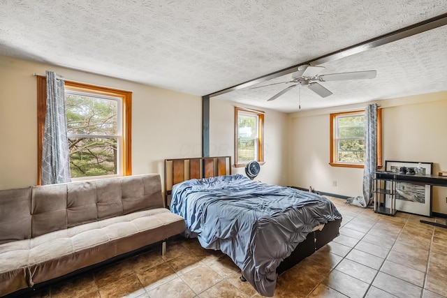 tiled bedroom with a textured ceiling and ceiling fan