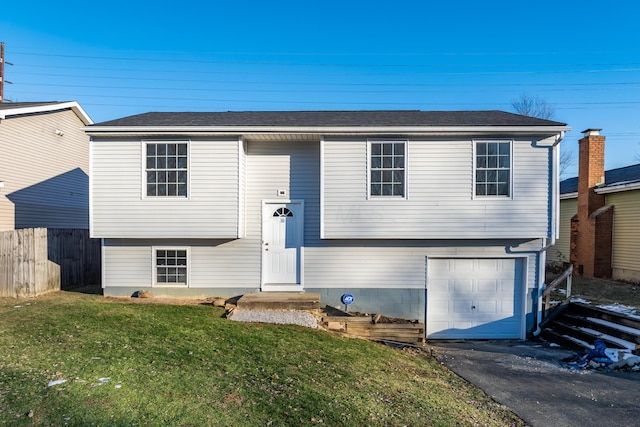 raised ranch with a garage and a front lawn