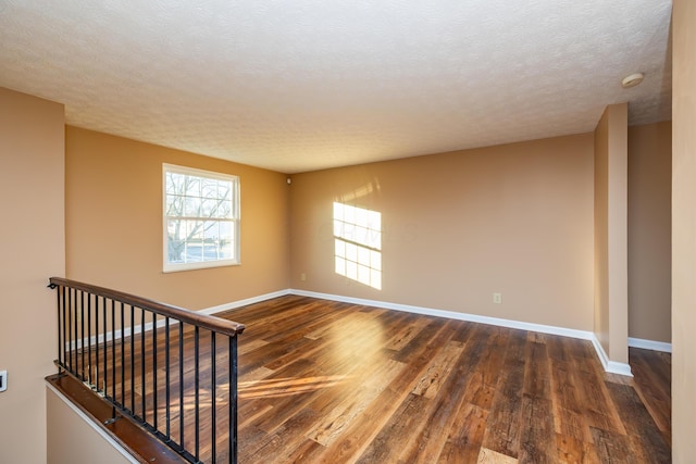 spare room with dark hardwood / wood-style flooring and a textured ceiling