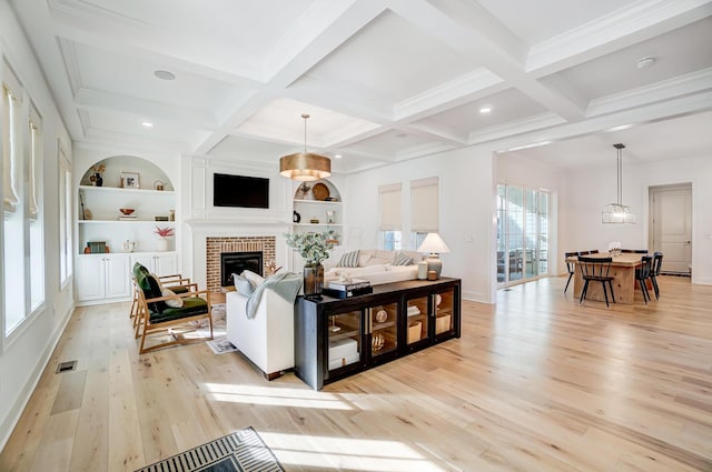 living room featuring coffered ceiling, beam ceiling, light hardwood / wood-style floors, and a brick fireplace