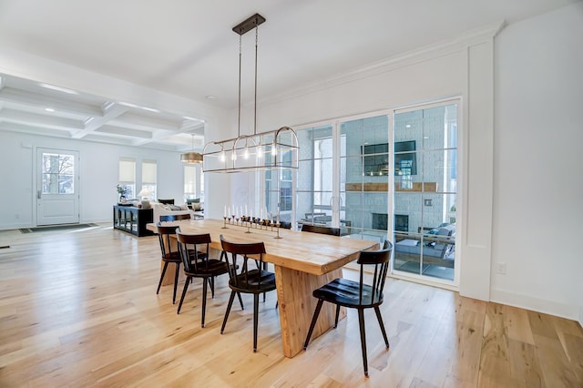 dining area with beam ceiling, coffered ceiling, a chandelier, and light wood-type flooring