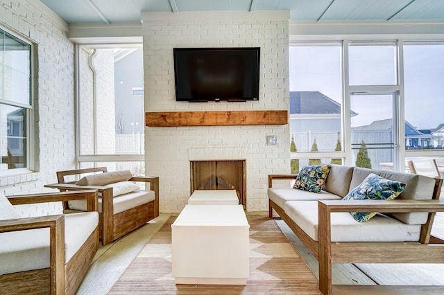 living room featuring light hardwood / wood-style floors and a brick fireplace