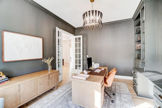 office space with an inviting chandelier, crown molding, french doors, and light wood-type flooring