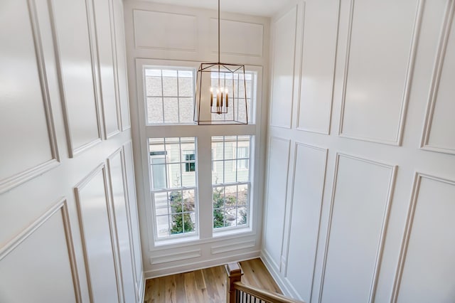 details with hardwood / wood-style floors and a notable chandelier