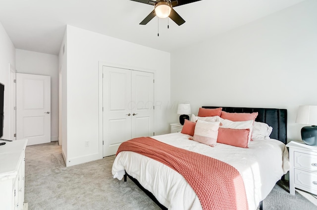 bedroom featuring light colored carpet, a closet, and ceiling fan