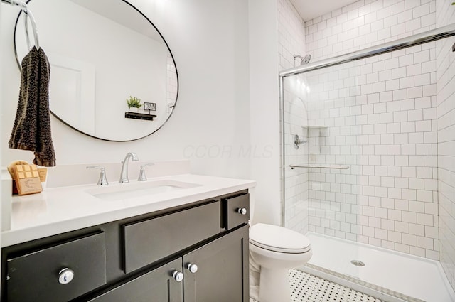 bathroom with vanity, a shower with shower door, and toilet