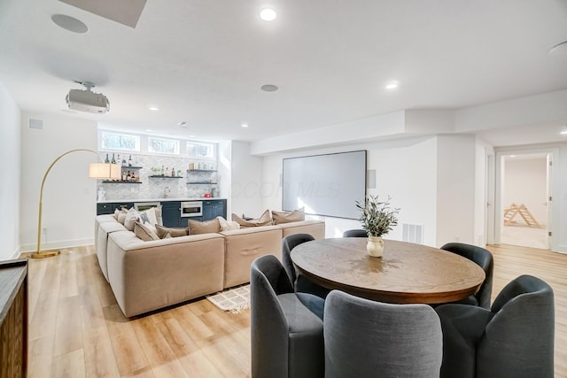 dining area featuring light hardwood / wood-style floors and indoor bar