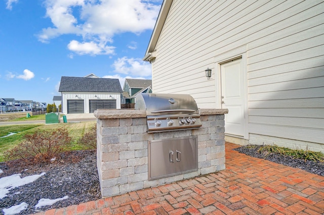 view of patio / terrace with area for grilling, a grill, a garage, and an outdoor structure