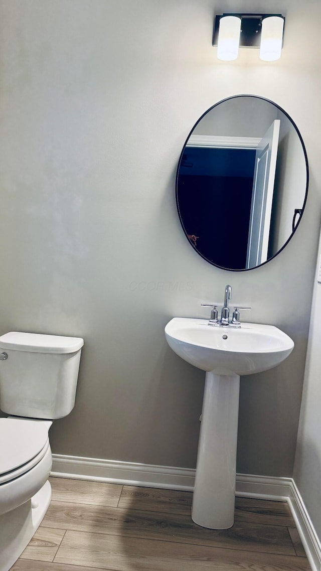 bathroom featuring sink, toilet, and hardwood / wood-style floors