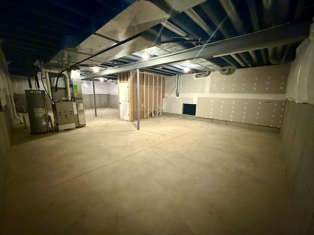 basement with electric water heater and heating unit