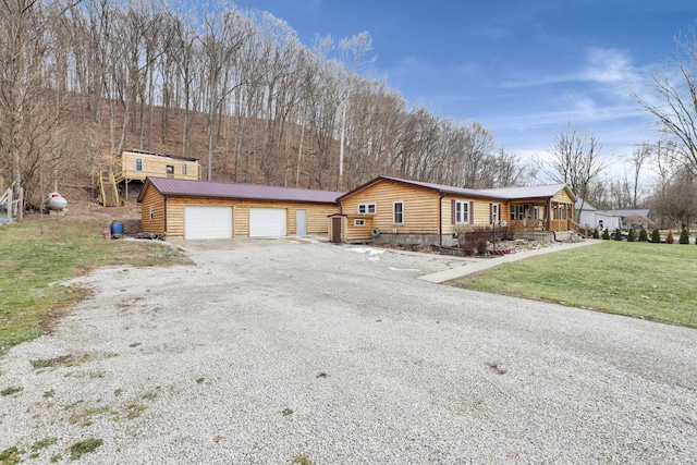 view of front of house with a porch, a garage, and a front lawn