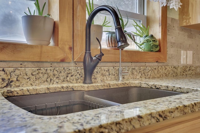 interior details featuring light stone counters and sink