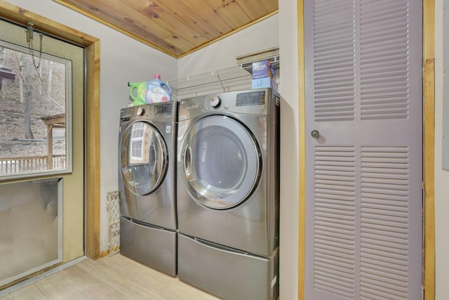 laundry area with wood ceiling, light hardwood / wood-style flooring, and washing machine and clothes dryer