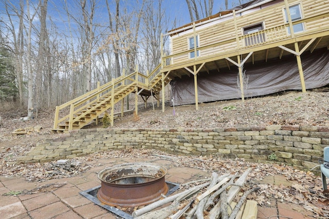 back of property featuring a wooden deck and an outdoor fire pit