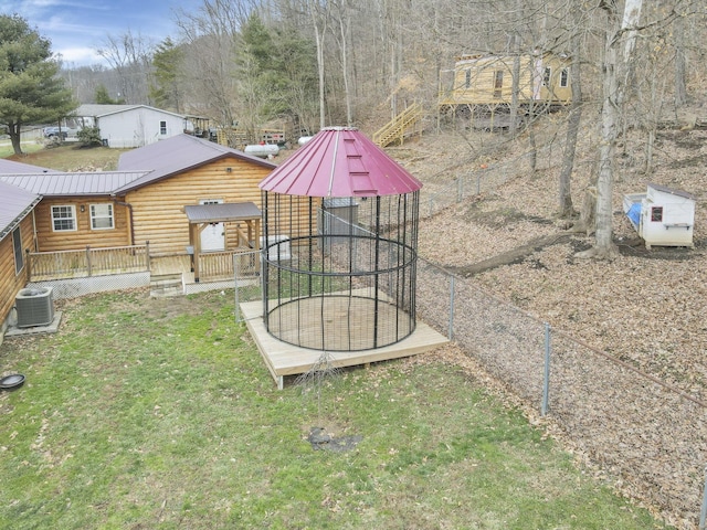 view of yard featuring a trampoline, central air condition unit, and a deck