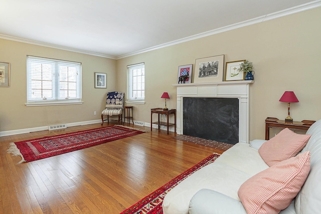 living room featuring ornamental molding, wood-type flooring, and visible vents