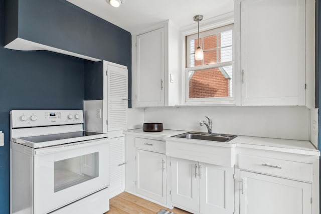 kitchen with white cabinetry, white range with electric cooktop, decorative light fixtures, and sink