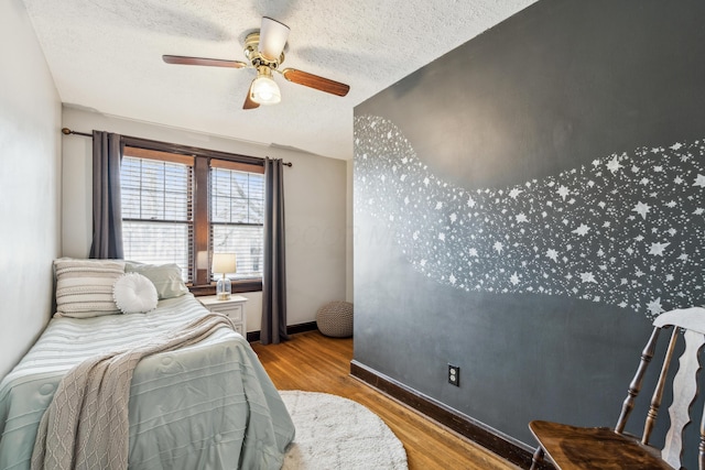 bedroom featuring ceiling fan, a textured ceiling, and light hardwood / wood-style flooring