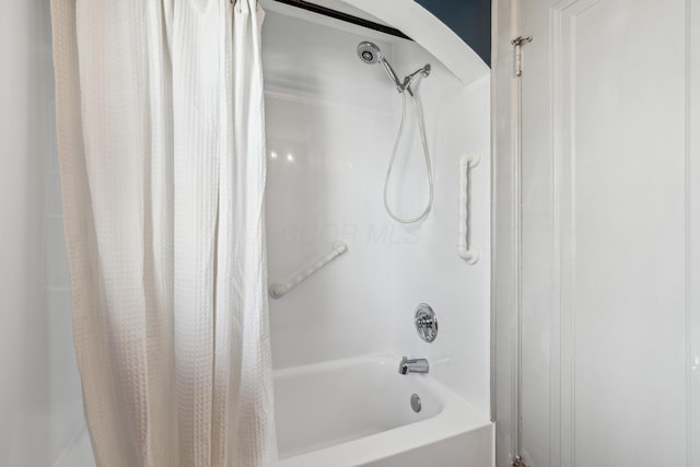 bathroom with shower / bath combo with shower curtain