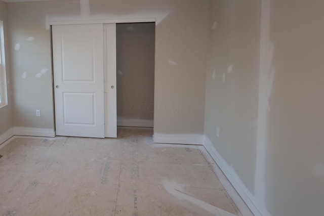 unfurnished bedroom featuring baseboards and a closet