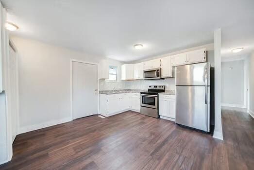 kitchen featuring appliances with stainless steel finishes, white cabinets, and dark hardwood / wood-style flooring