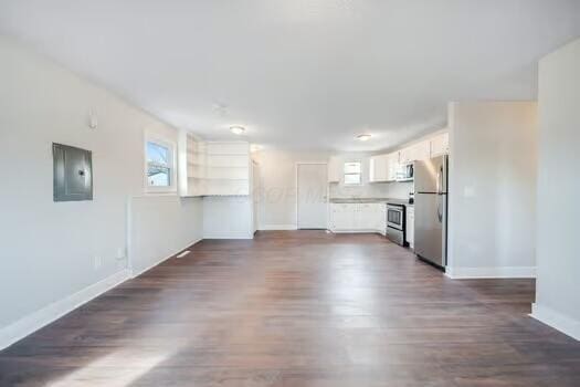 kitchen featuring white cabinetry, dark hardwood / wood-style flooring, stainless steel appliances, and electric panel