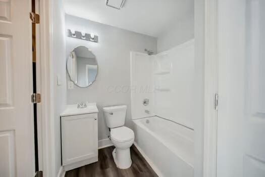 full bathroom with shower / bathing tub combination, hardwood / wood-style floors, vanity, and toilet