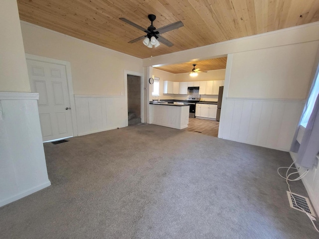 unfurnished living room featuring ceiling fan, light carpet, and wooden ceiling