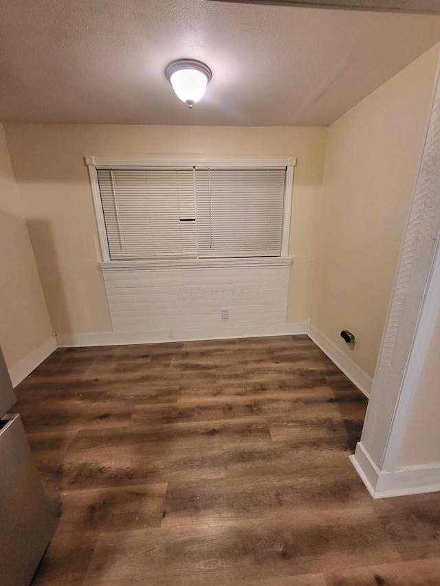 laundry area with dark hardwood / wood-style flooring and a textured ceiling