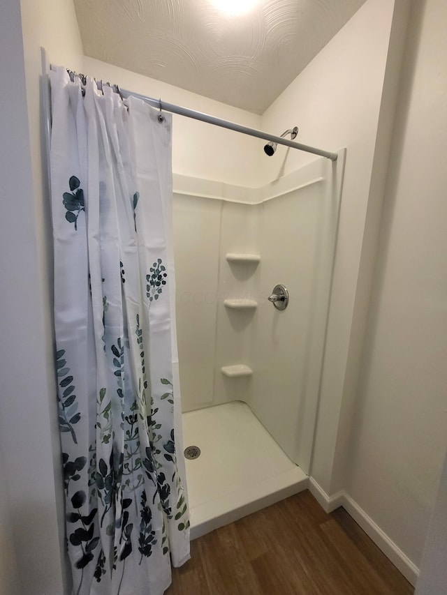 bathroom with hardwood / wood-style floors and a shower with curtain