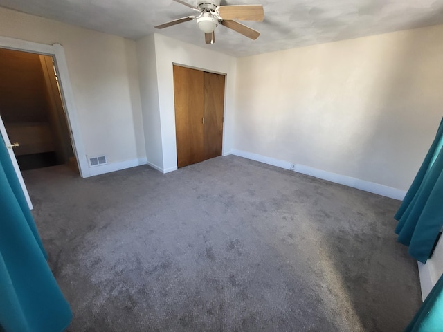 unfurnished bedroom with a closet, ceiling fan, and dark colored carpet