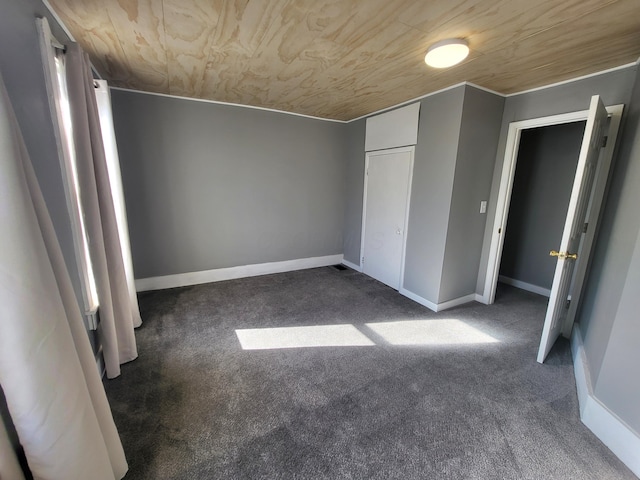 unfurnished bedroom featuring wooden ceiling and dark colored carpet