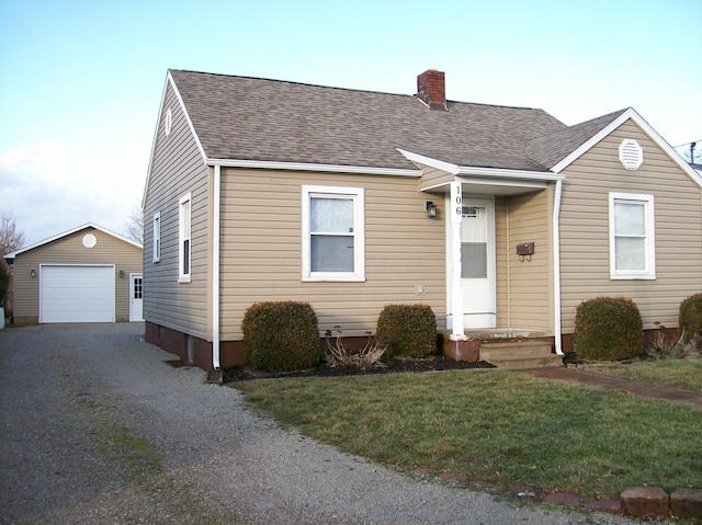 view of front facade featuring an outbuilding, a garage, and a front yard