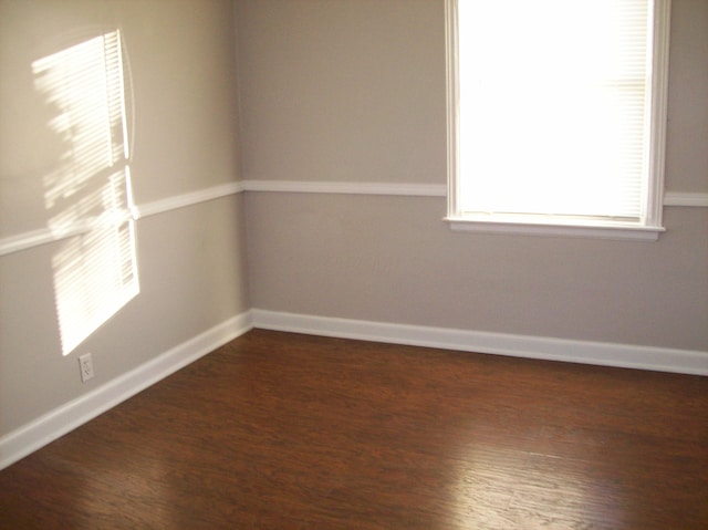 empty room with dark hardwood / wood-style flooring