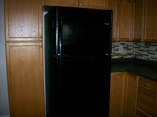 kitchen with tasteful backsplash and black fridge