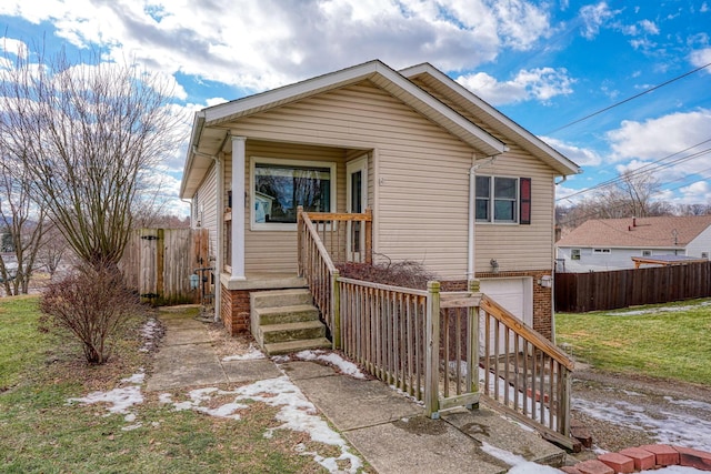 bungalow-style home with a garage and a front lawn