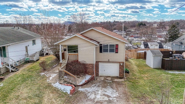 rear view of property featuring a garage, a yard, and a shed