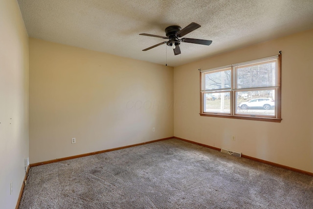 empty room featuring ceiling fan, carpet flooring, and a textured ceiling