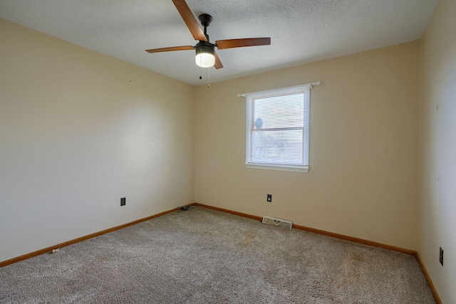 carpeted empty room featuring ceiling fan and a textured ceiling