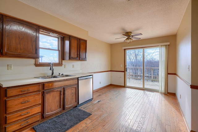 kitchen with a healthy amount of sunlight, sink, dishwasher, and light wood-type flooring