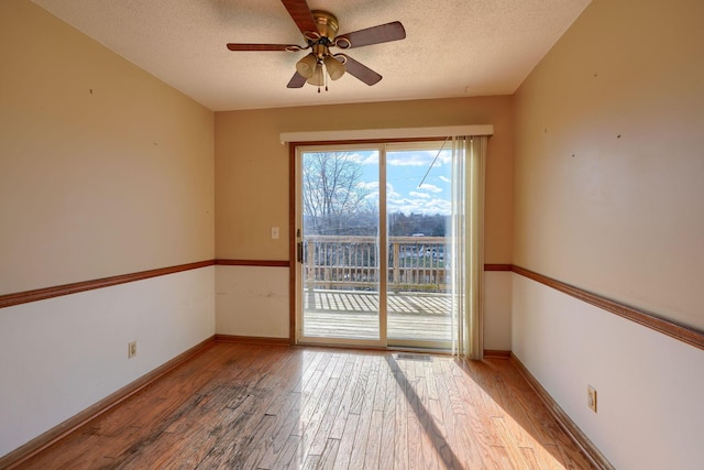 empty room featuring ceiling fan, light hardwood / wood-style floors, and a textured ceiling