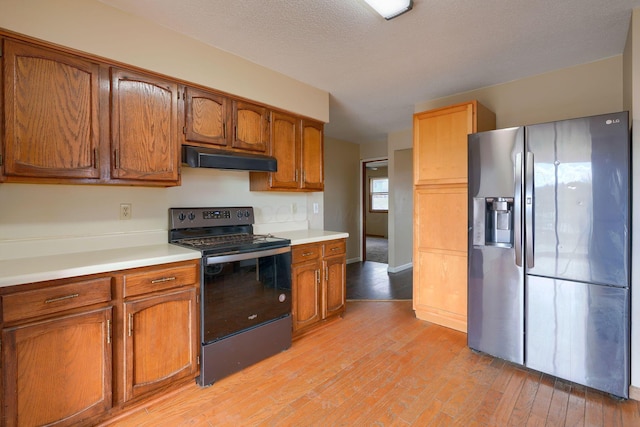 kitchen with stainless steel refrigerator with ice dispenser, a textured ceiling, light hardwood / wood-style floors, and electric stove