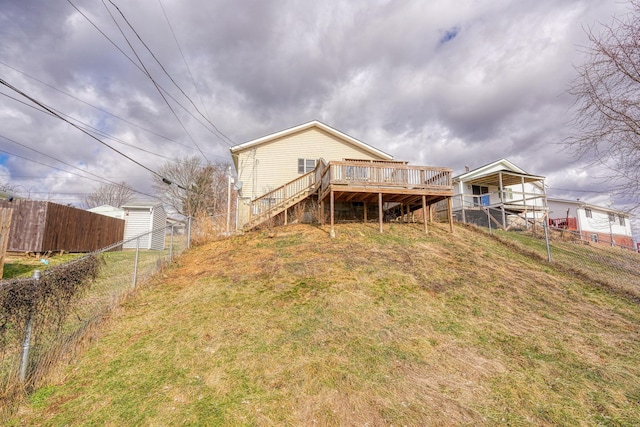 rear view of house with a wooden deck and a yard