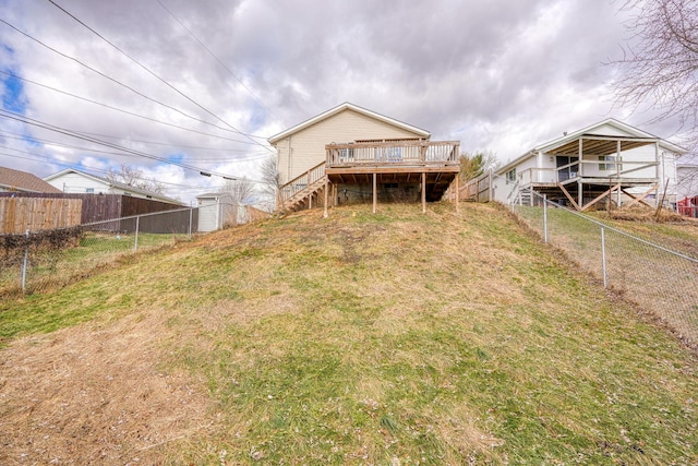 back of property featuring a wooden deck and a yard