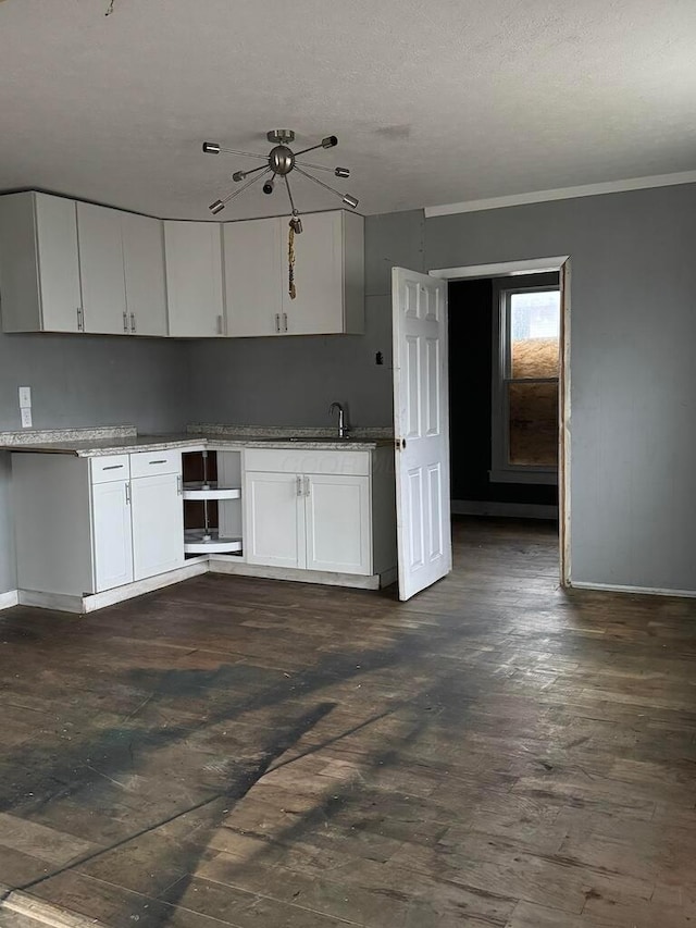 kitchen with white cabinetry, sink, dark hardwood / wood-style flooring, crown molding, and a textured ceiling