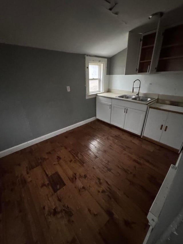 kitchen featuring white cabinetry, vaulted ceiling, sink, and dark hardwood / wood-style flooring