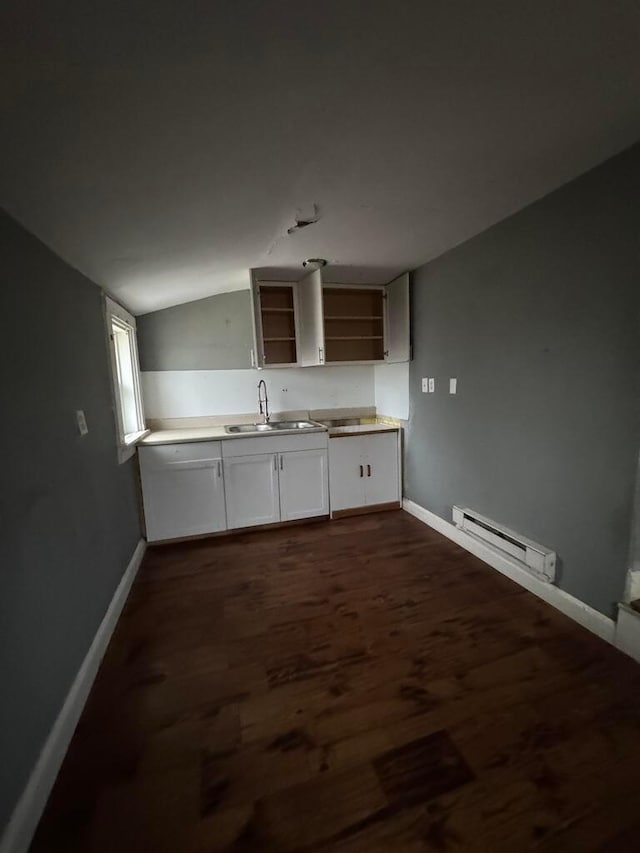 kitchen featuring sink, vaulted ceiling, white cabinetry, dark hardwood / wood-style flooring, and a baseboard radiator