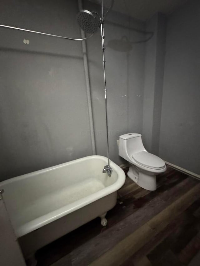 bathroom with a bath, hardwood / wood-style floors, and toilet