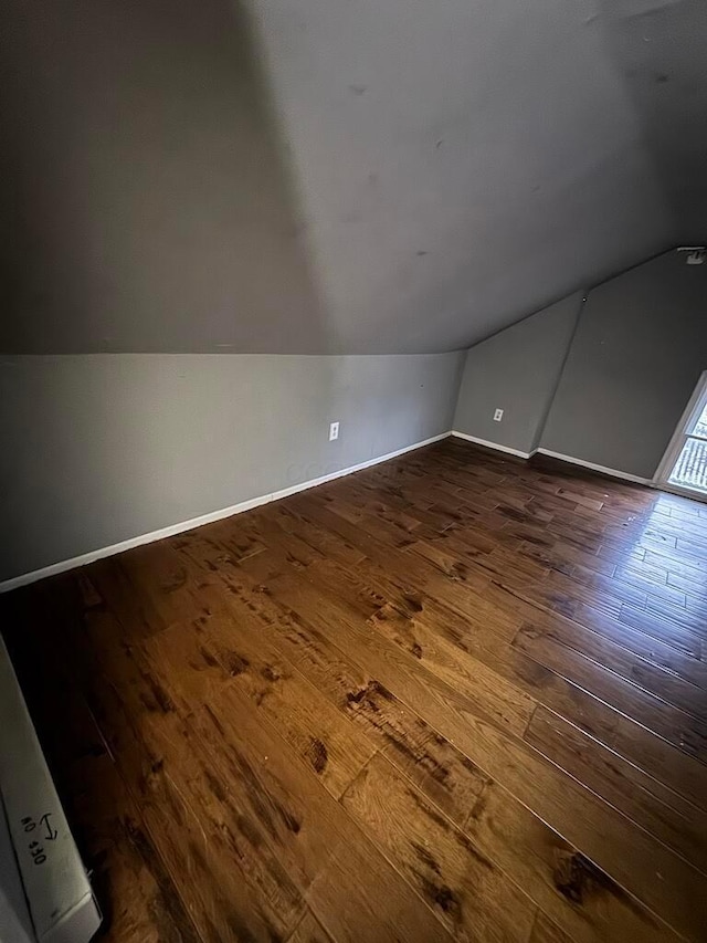 bonus room with lofted ceiling and dark hardwood / wood-style floors